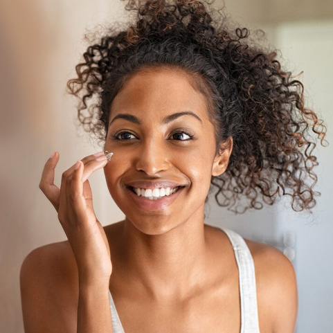 Woman applying face acne treatment